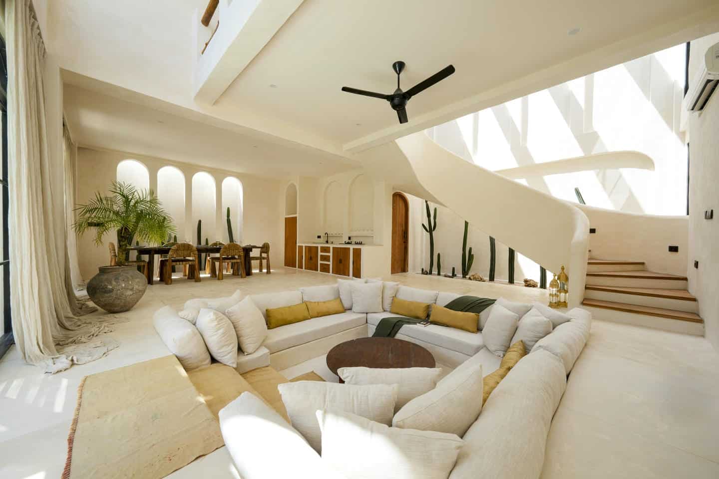 Spacious living room with modern decor and staircase.