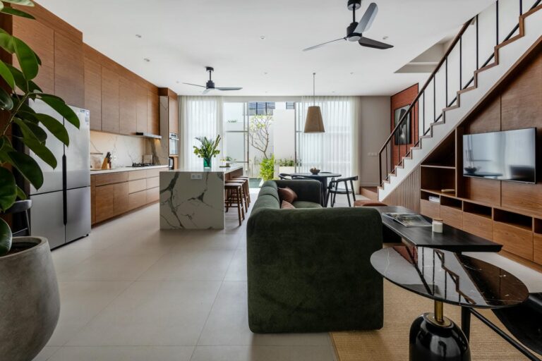 Modern open-plan kitchen and living room with staircase.