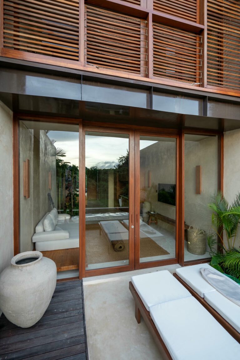 Modern patio with glass doors and lounge chairs.
