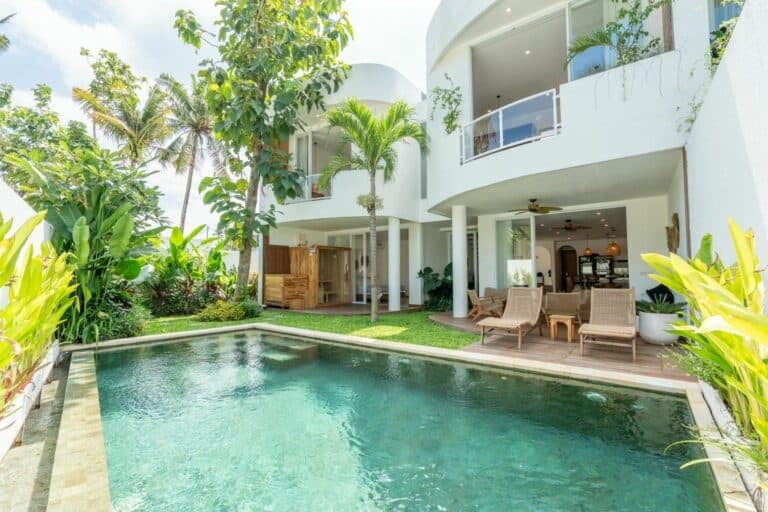 Modern villa with pool and tropical garden view.