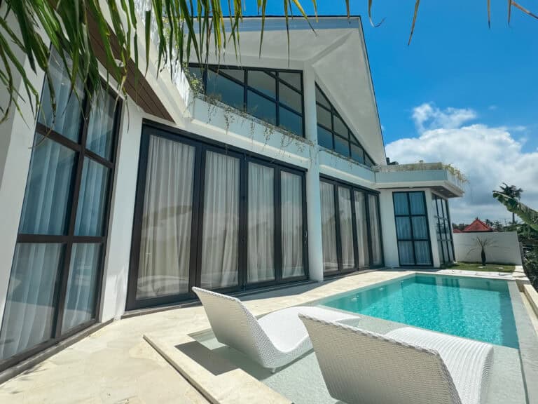 Modern house with pool and lounge chairs.