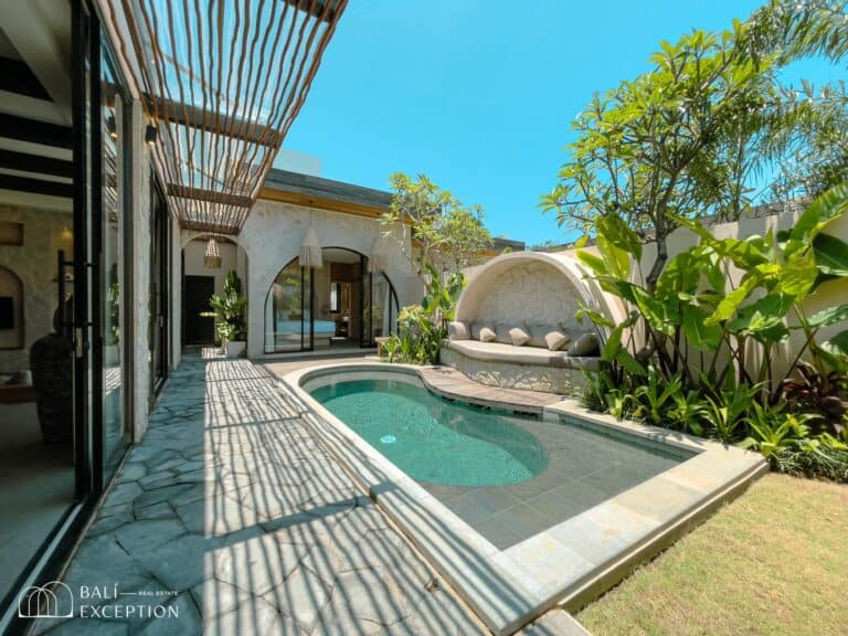 Modern villa courtyard with pool and greenery.