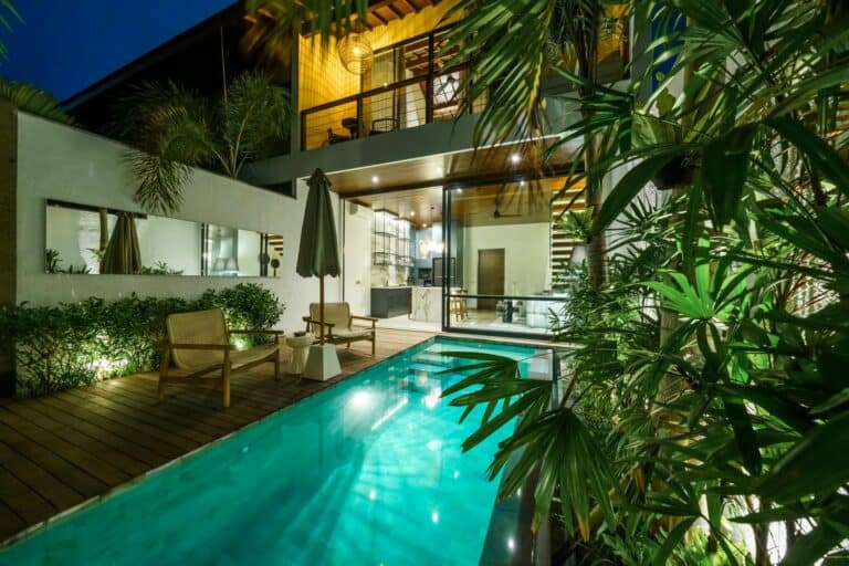 Modern house with illuminated pool and patio at night.