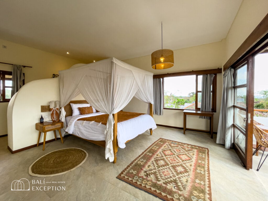 Spacious, cozy bedroom with canopy bed and natural light.
