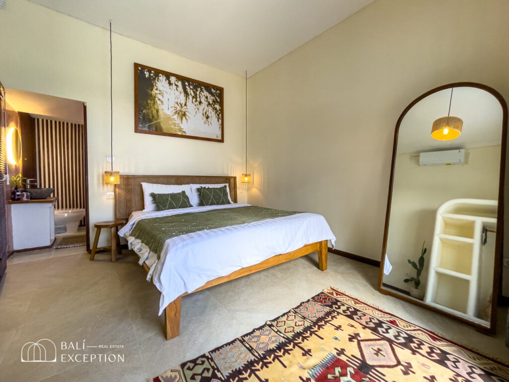 Cozy bedroom with a double bed and large mirror.