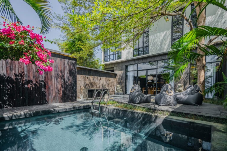 Modern backyard with pool, patio, and bean bags.