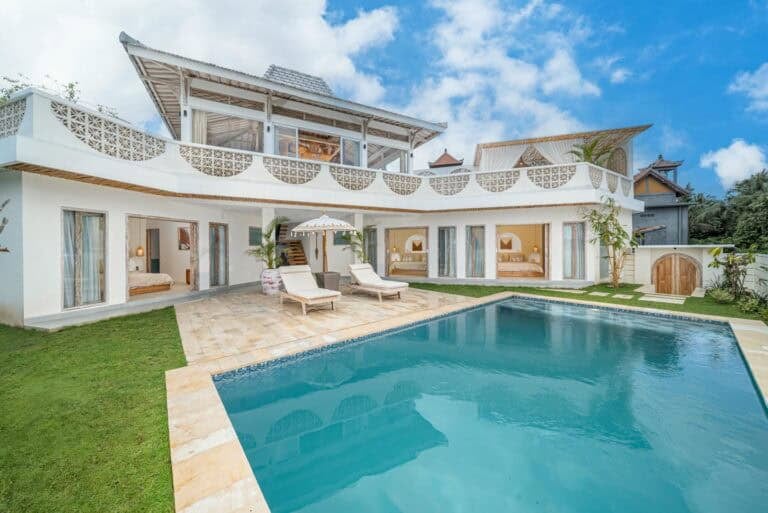 Modern villa with pool and patio on sunny day.