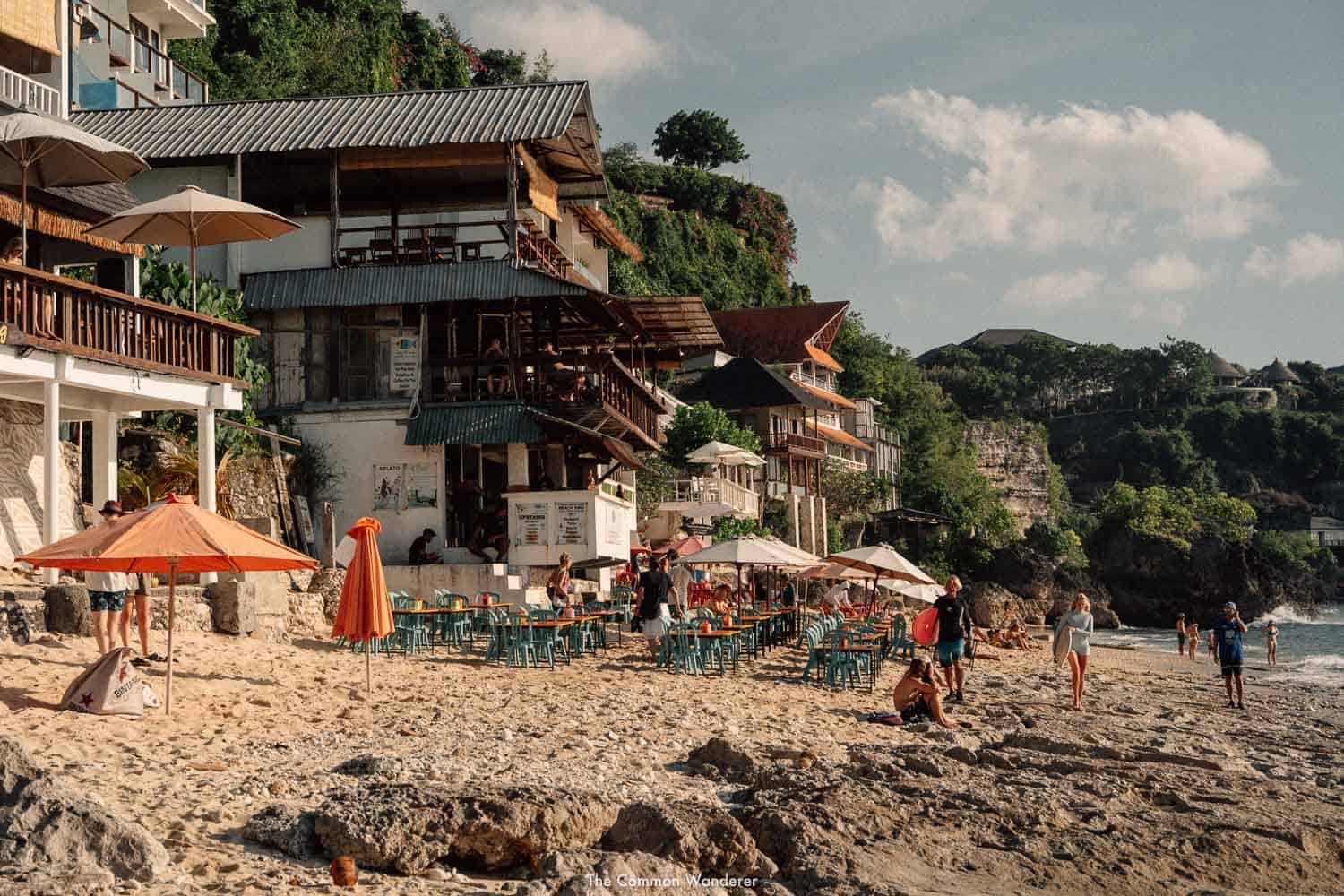 Beachside cafes and tourists at a tropical beach.