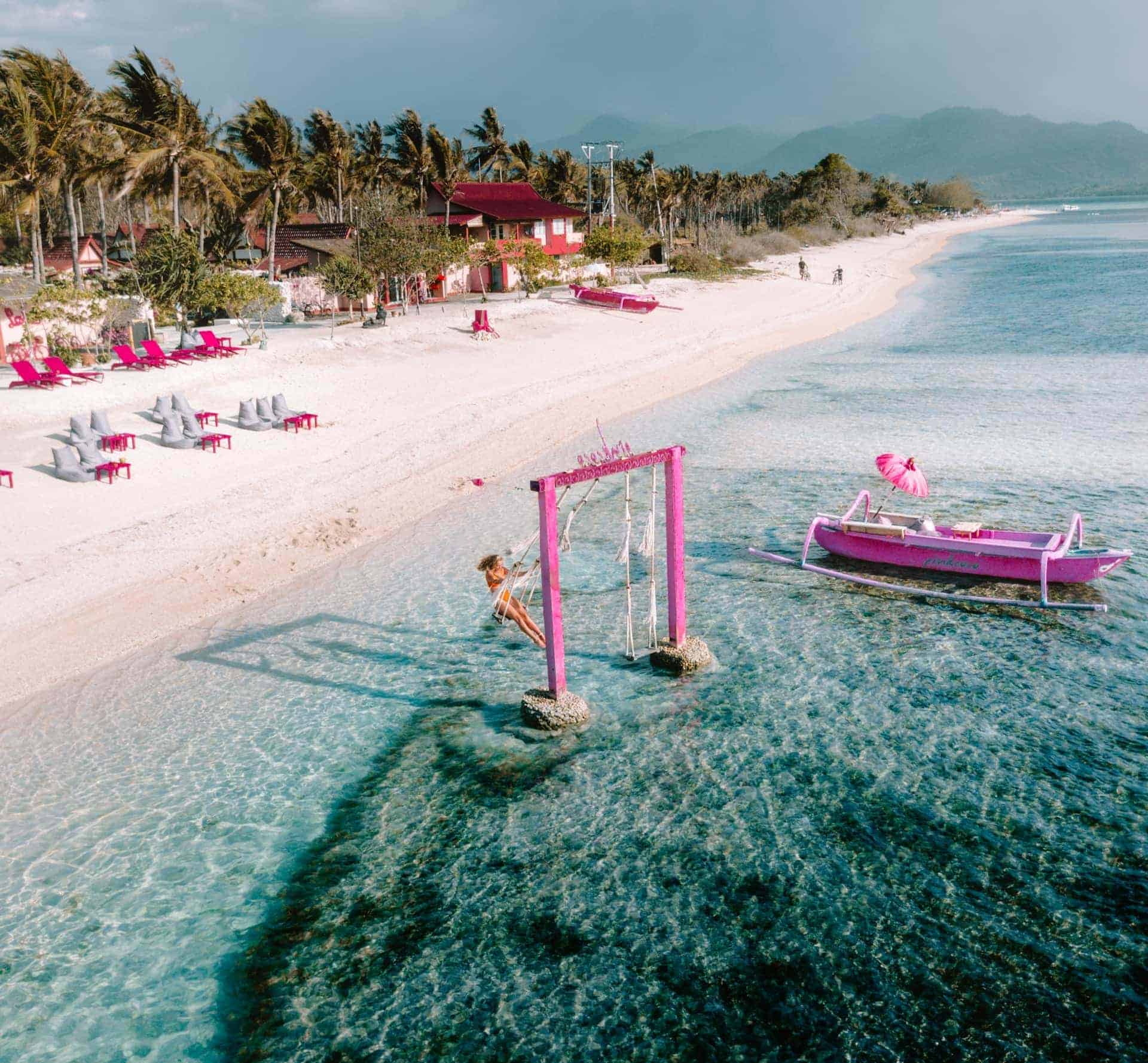 Tropical beach, swing in ocean, pink boat.