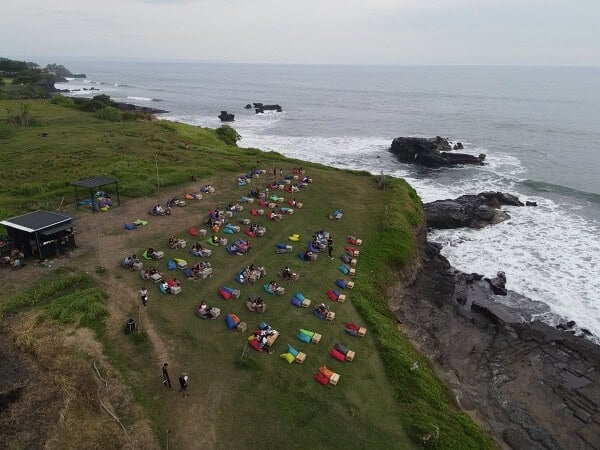 Outdoor event near the coast with people and tents.