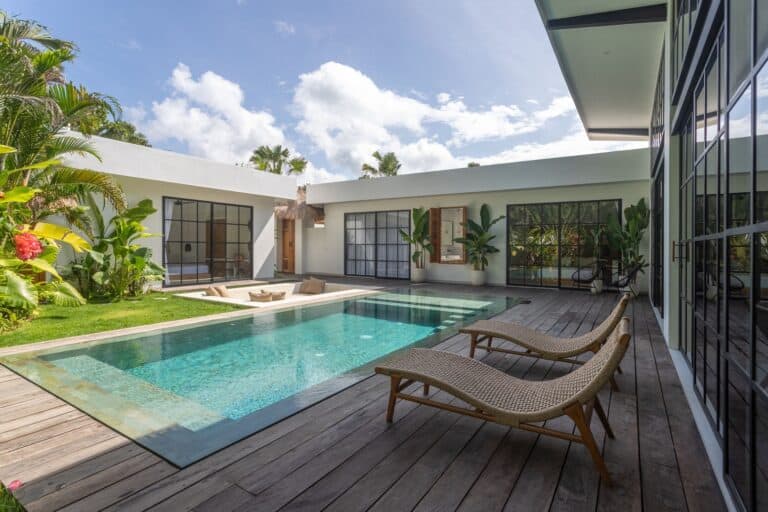 Modern house with outdoor pool and lounge chairs.