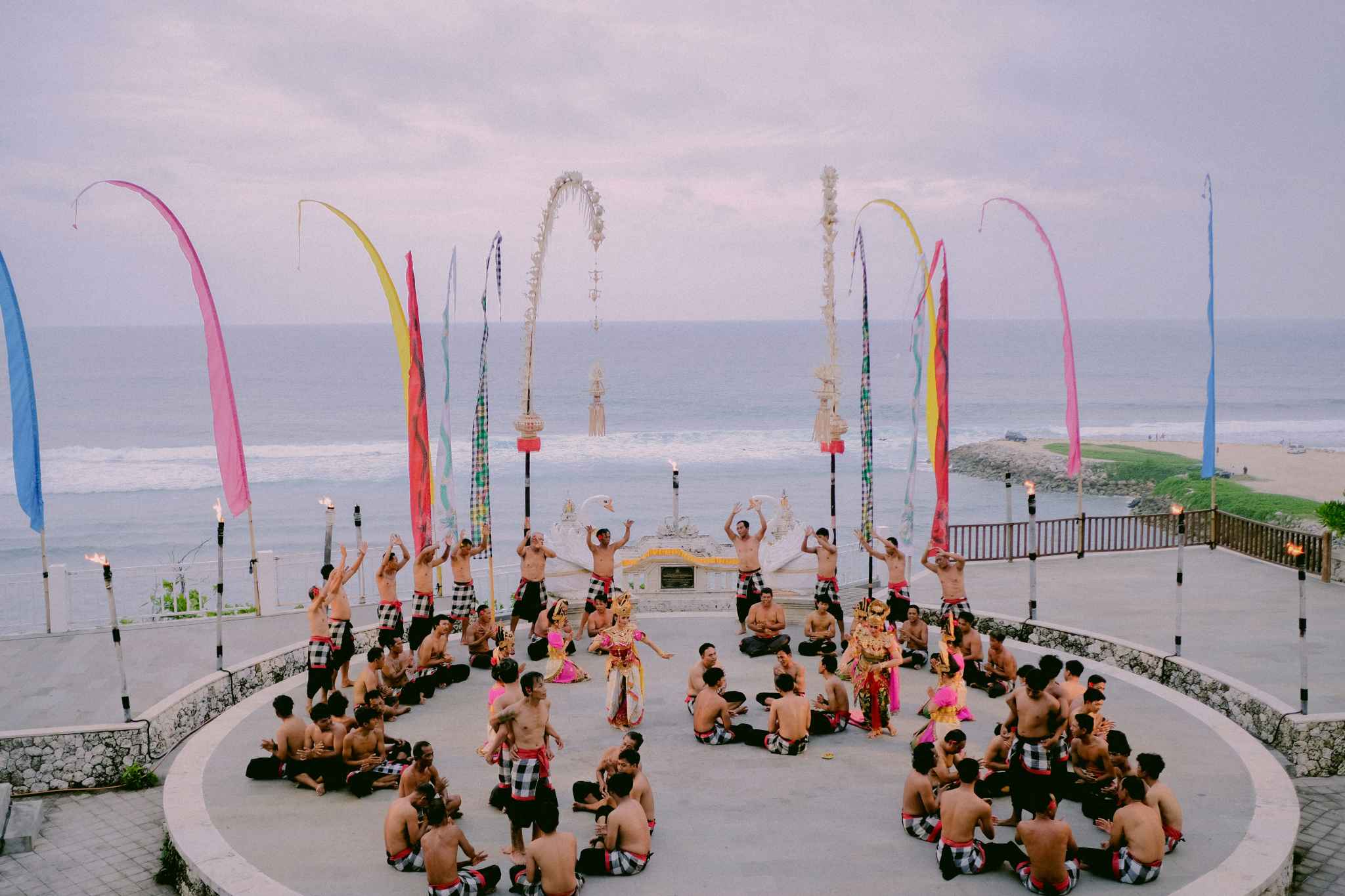 Traditional dance performers by the sea with flags