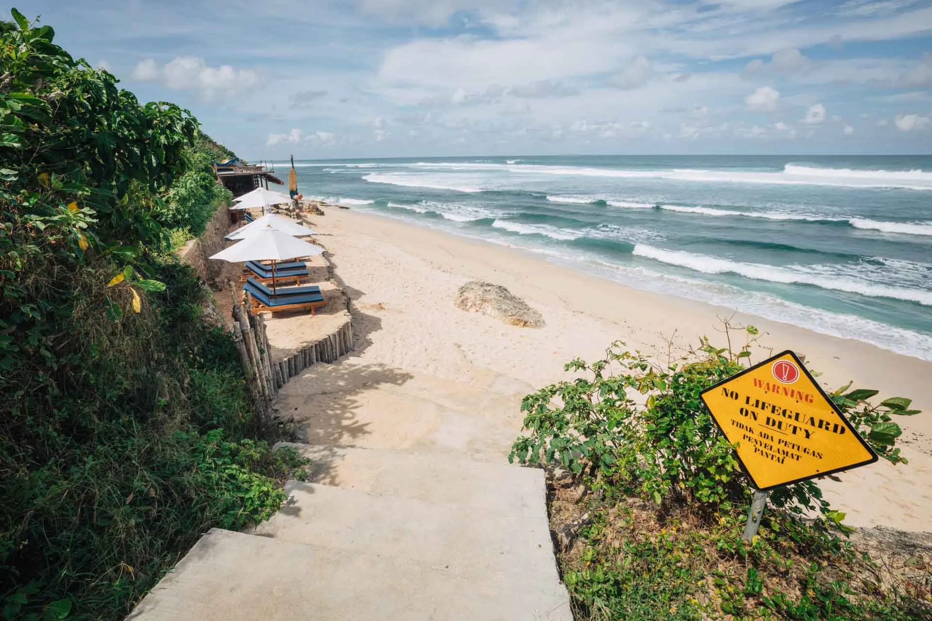 Secluded beach with no lifeguard warning sign.