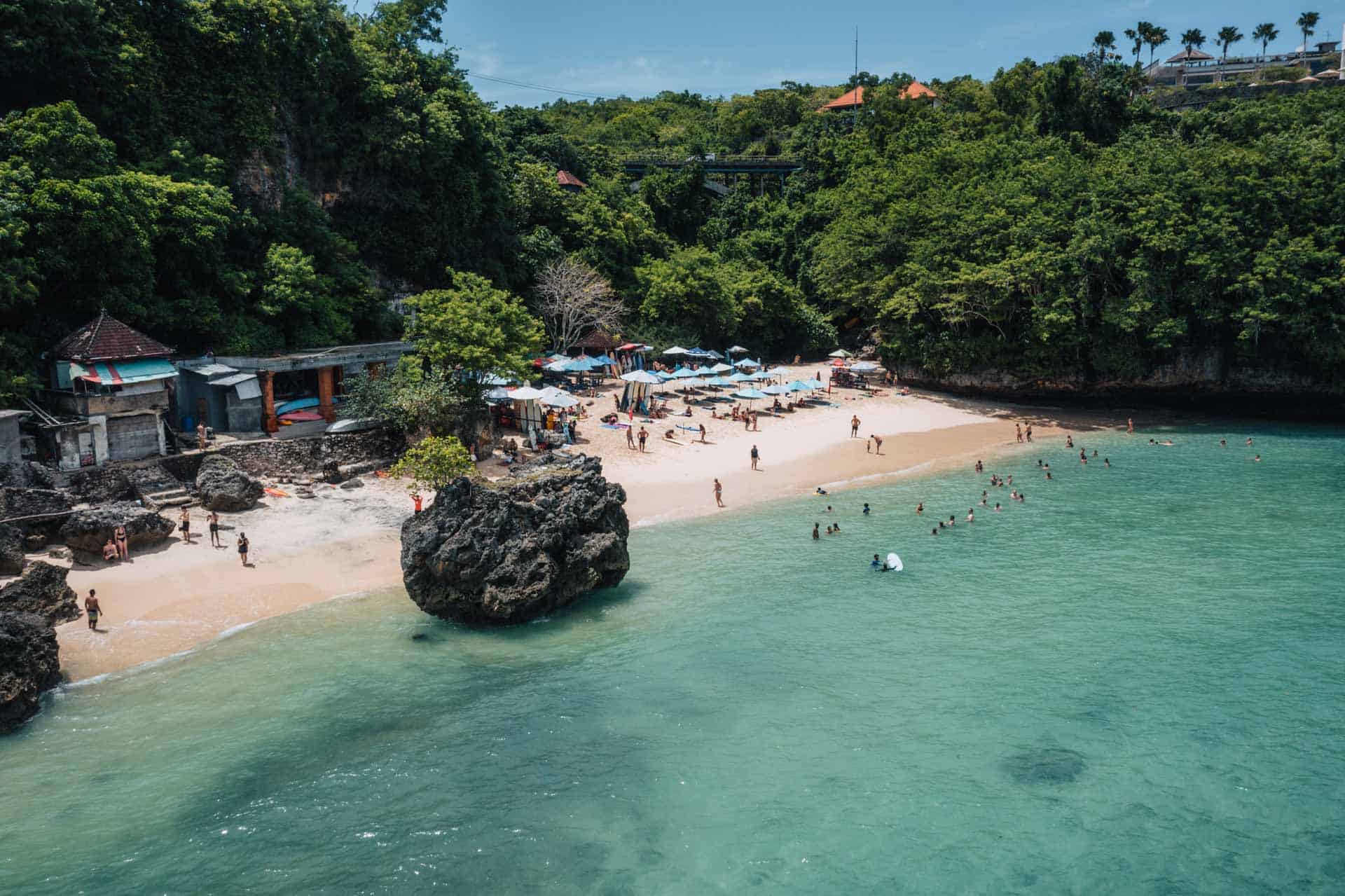 Tropical beach with people swimming and relaxing.