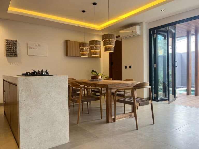 Modern kitchen with wood dining table, island and lights.