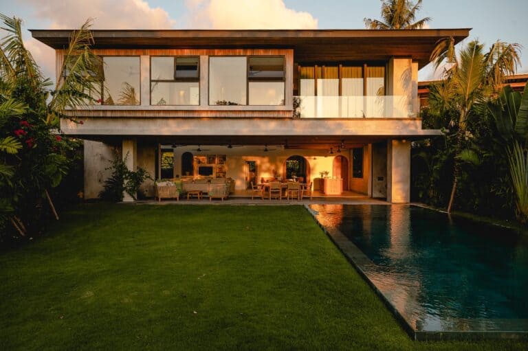 Modern house with garden and pool at sunset.