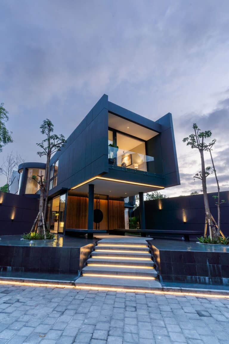 Modern architectural home at dusk with lights on.
