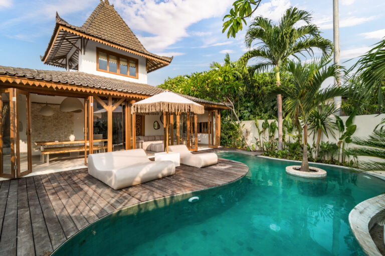 Tropical villa with pool and palm trees.