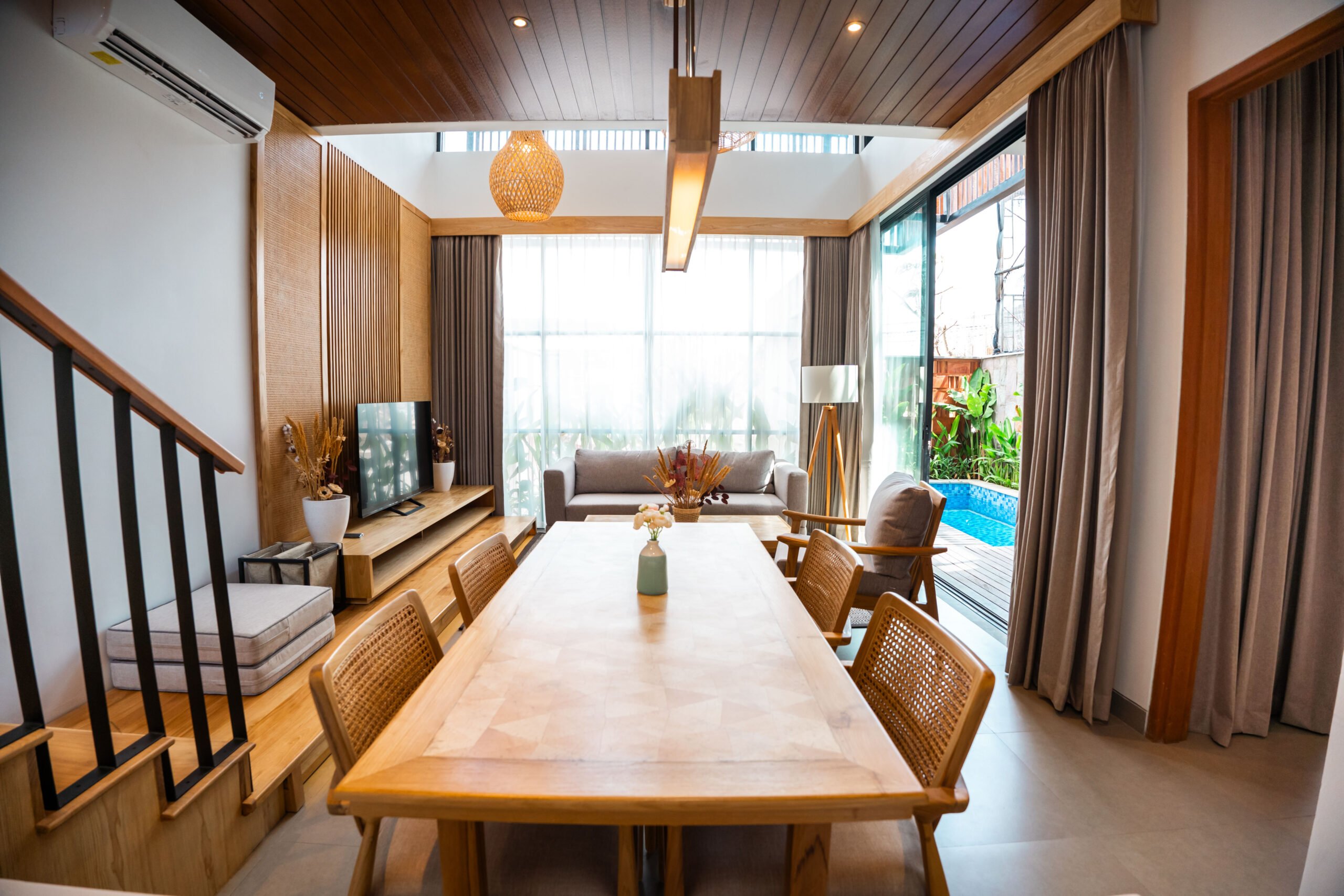 Modern living room with dining area and pool view.