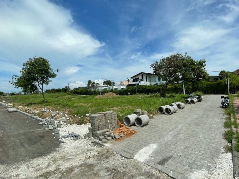 Residential area under construction with materials on roadside.