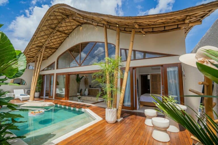 Luxury bamboo villa with pool and plants.