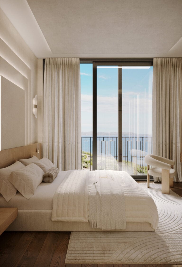 Modern bedroom with ocean view through large window.