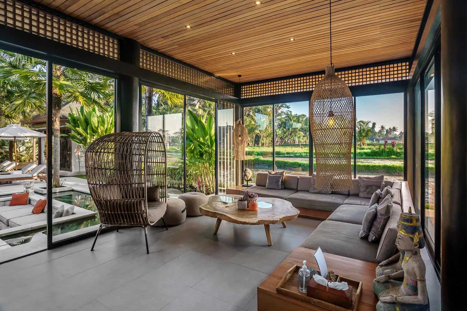 Modern living room with garden view and wicker furniture.