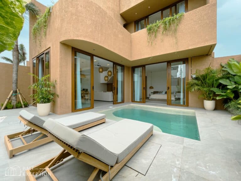 Modern villa with poolside loungers and tropical plants.