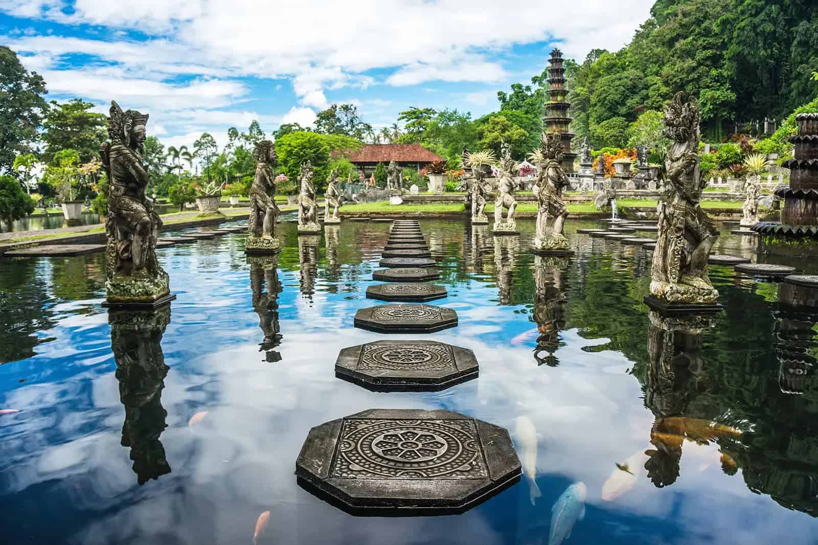 Bali water palace with statues and reflection.