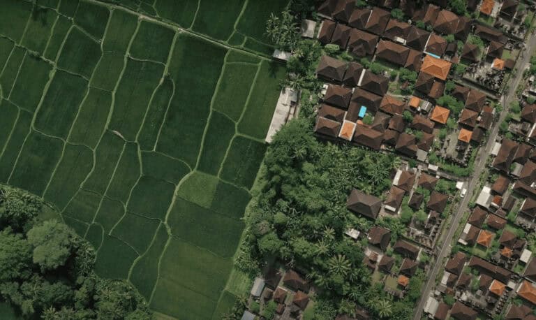 Aerial view of green fields and houses