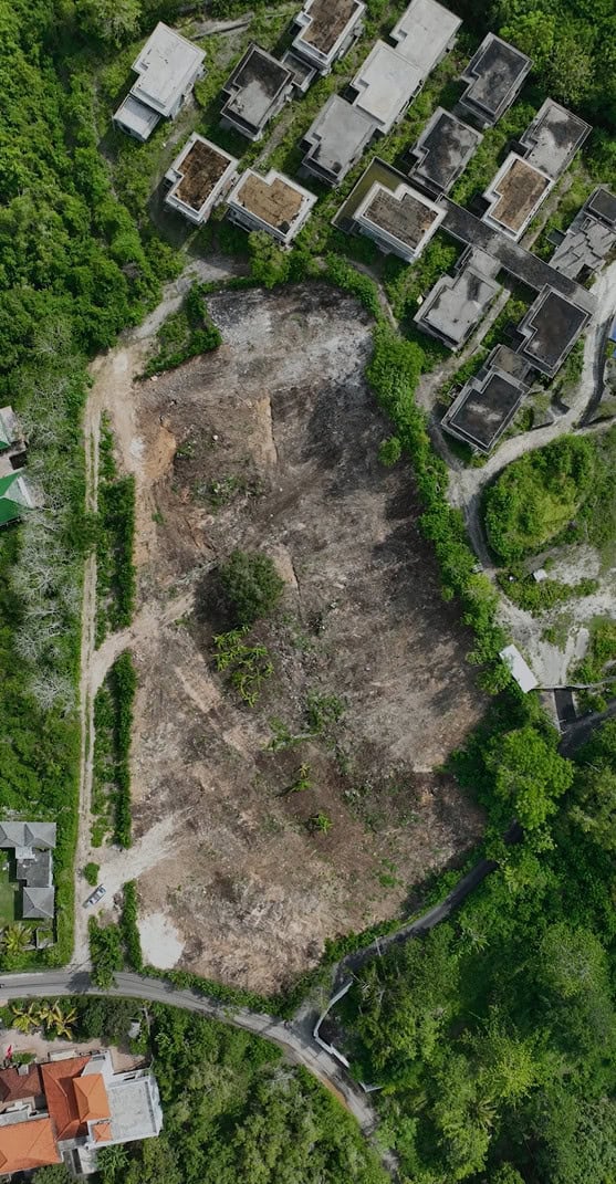 Aerial view of cleared land and adjacent buildings.