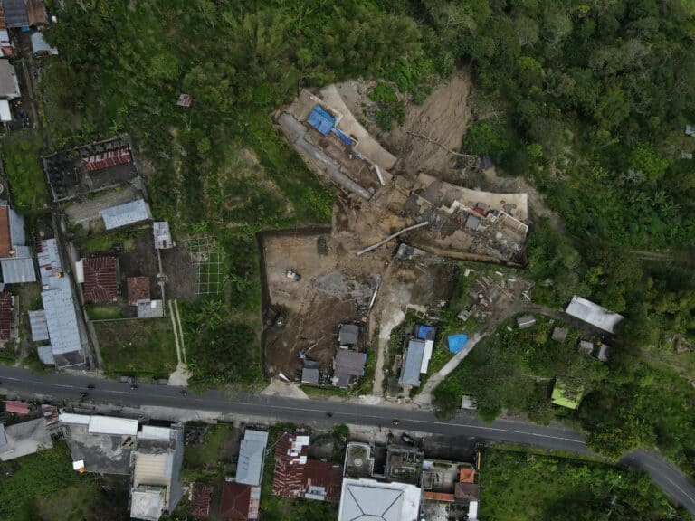 Aerial view of landslide affecting town area and forest.