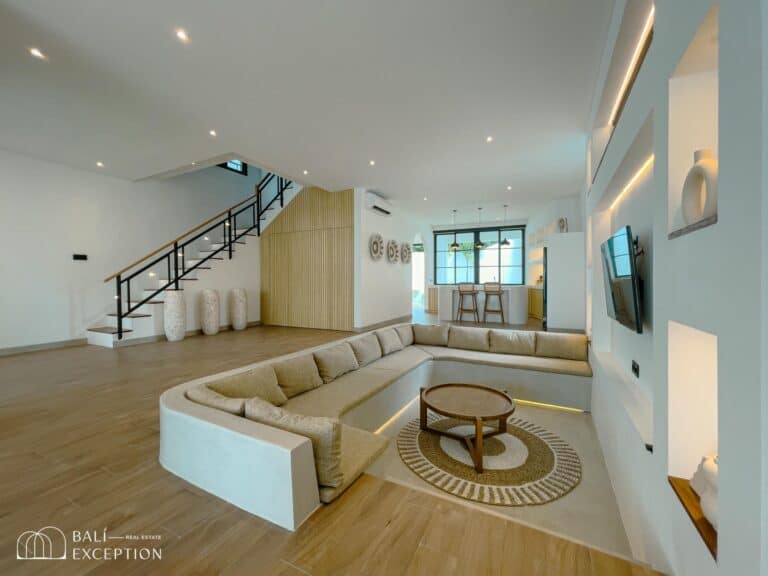 Modern living room with sectional sofa and staircase.