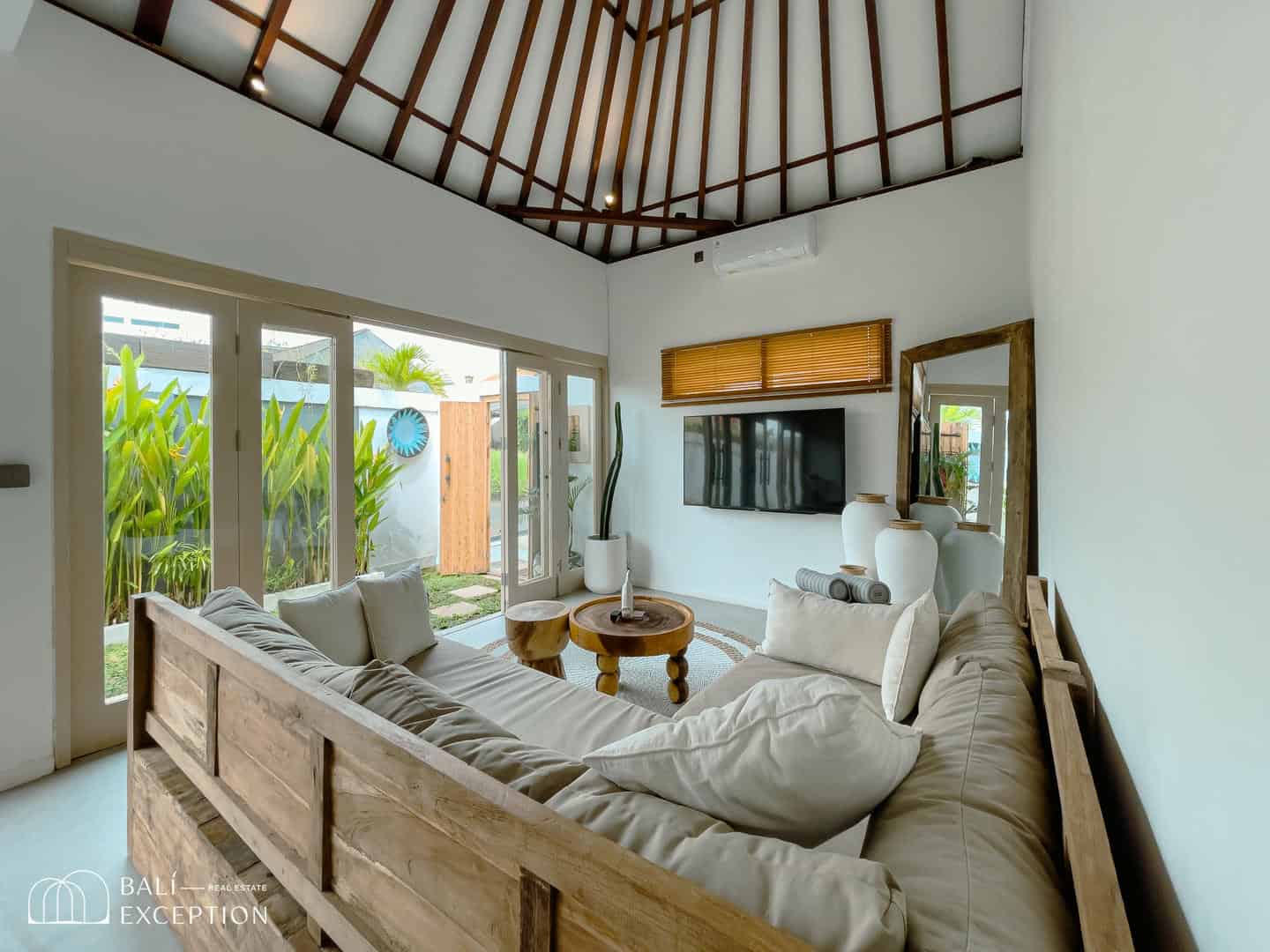 Modern living room with large windows and wooden decor.