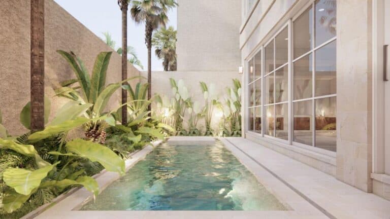 Modern house pool with tropical plants and palm trees.