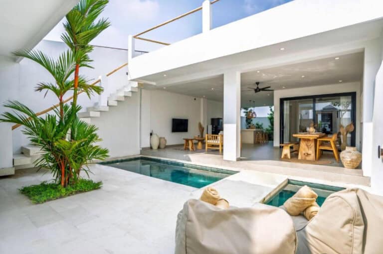 Modern villa courtyard with pool and seating area.