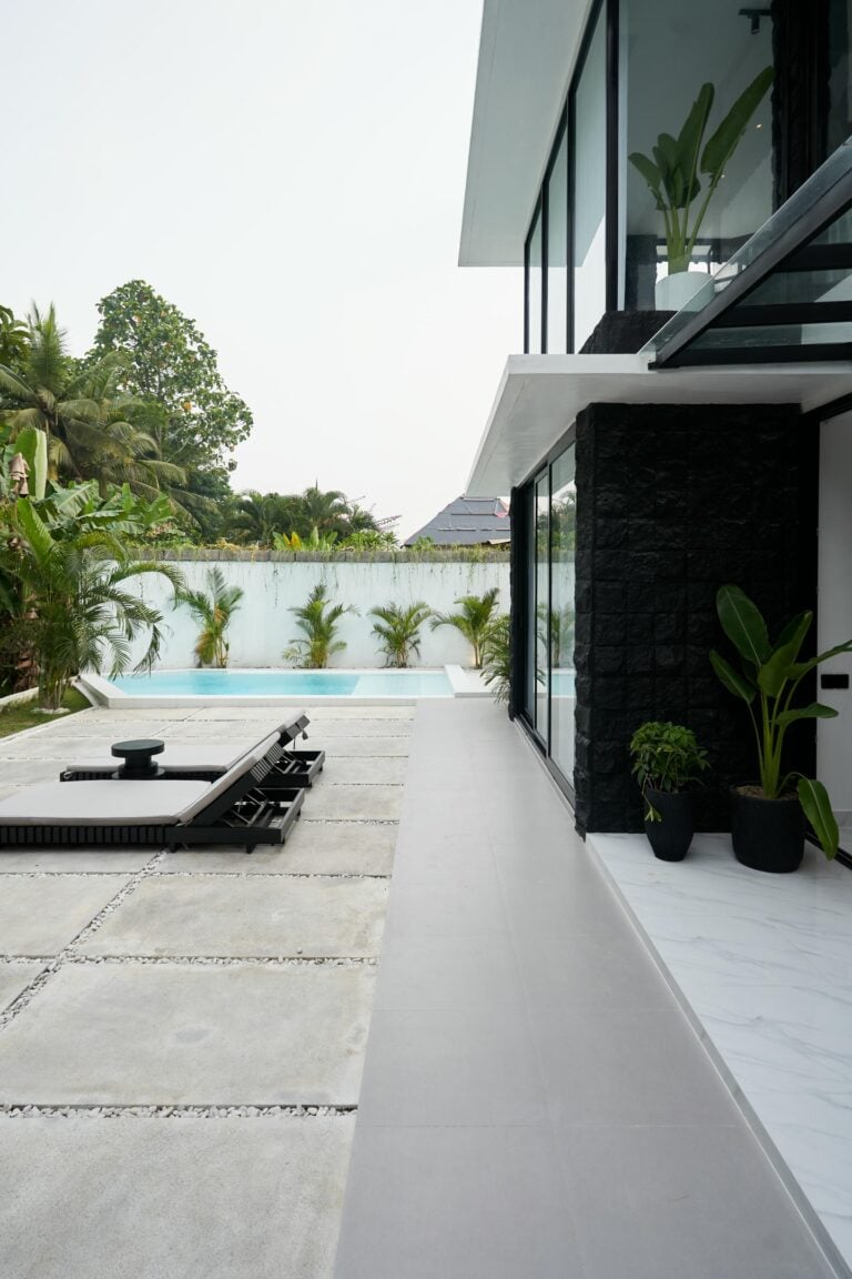 Modern house with pool and tropical plants.