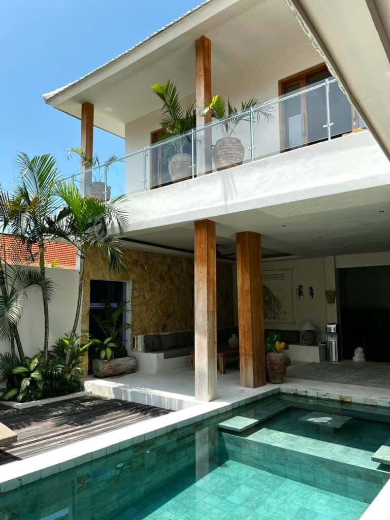 Modern house with pool, balcony, and plants.