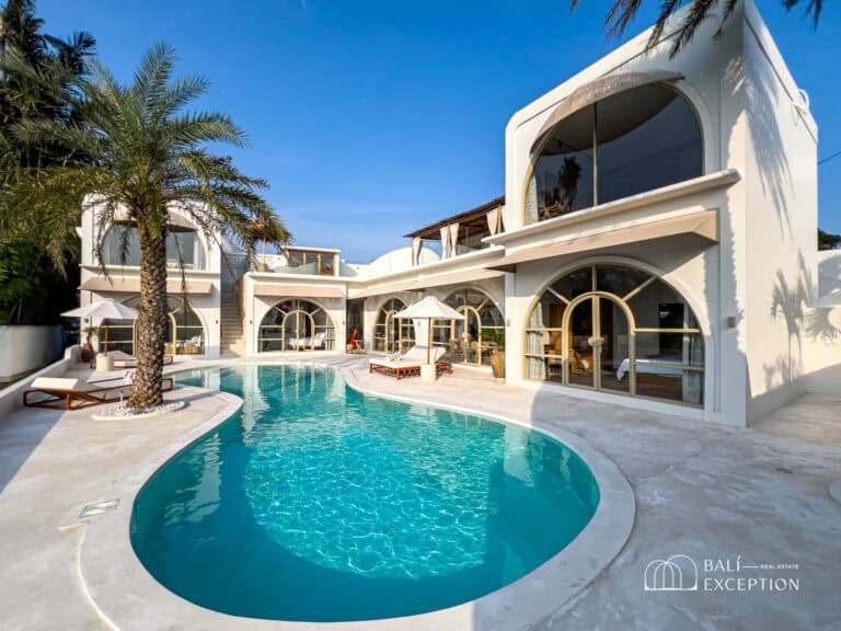 Luxury villa with pool under clear blue sky.