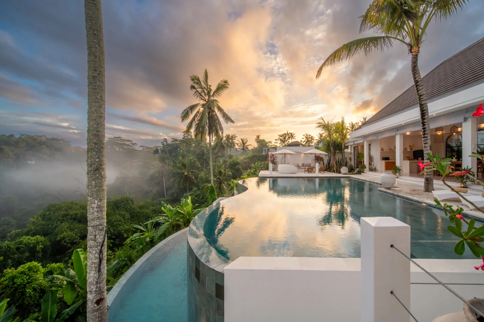 Luxury villa with infinity pool and tropical sunset