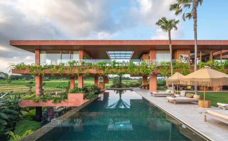 Modern villa with pool and green landscape.