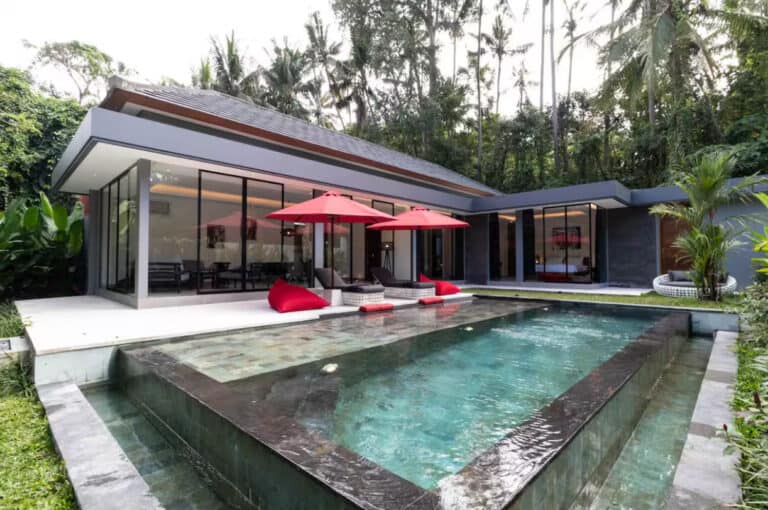 Modern villa with pool and red umbrellas.