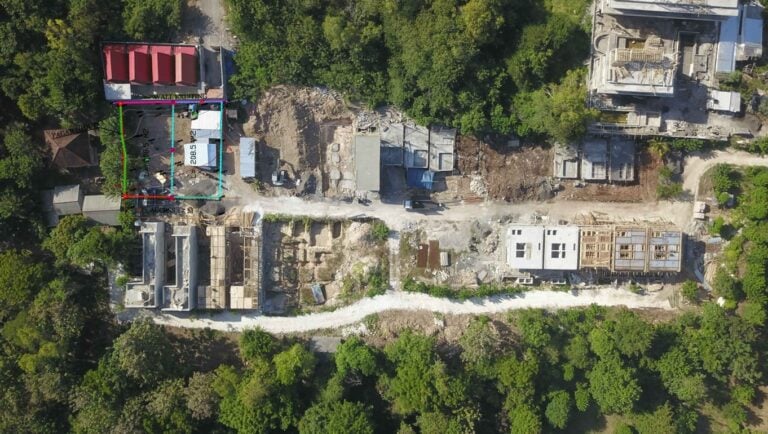 Aerial view of construction site surrounded by trees.