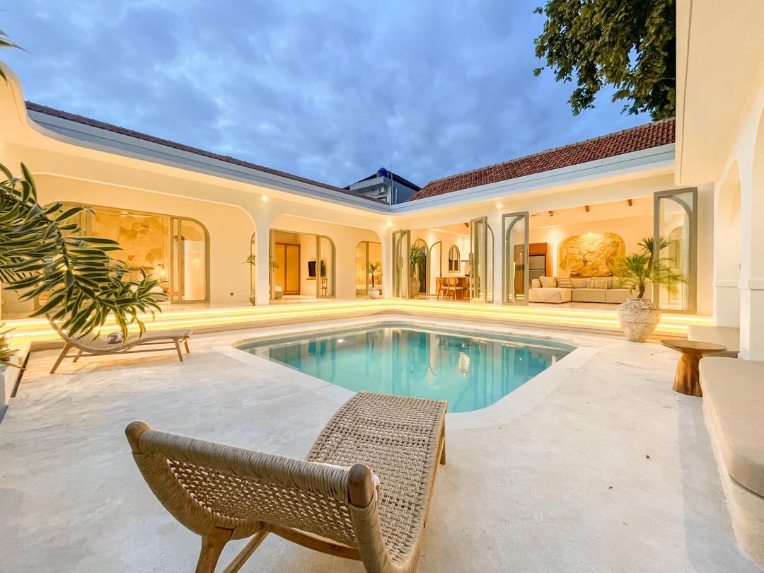 Luxurious villa courtyard with pool at dusk.