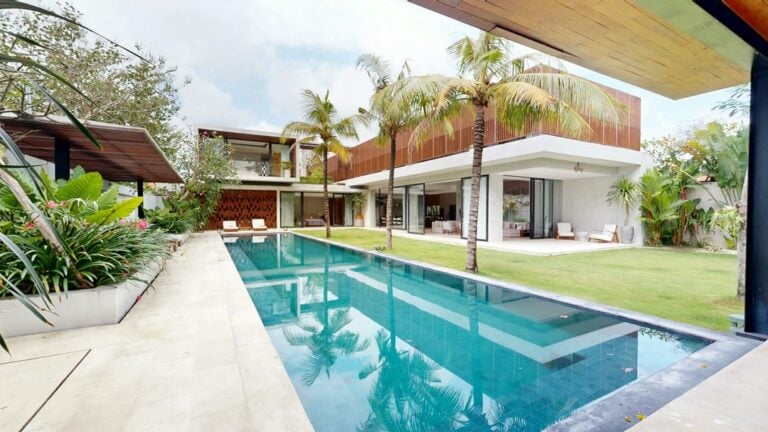 Modern villa with pool and palm trees.