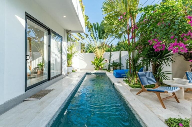 Modern patio with pool and tropical plants.