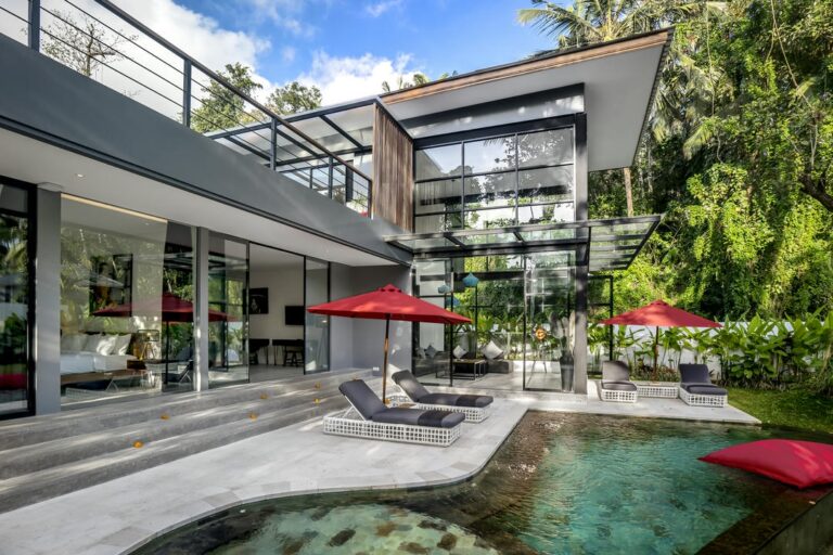 Modern villa with pool and red umbrellas.