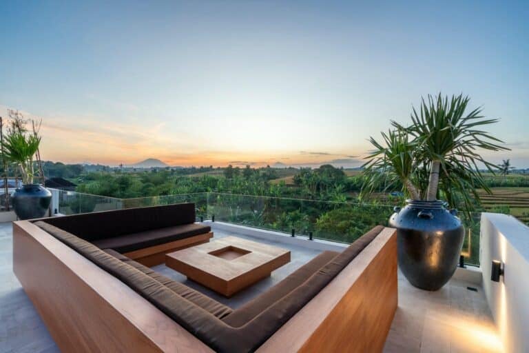 Outdoor terrace with view of lush landscape and sky.