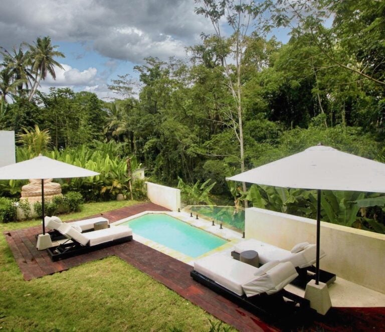 Tropical pool with lounge chairs and umbrellas.