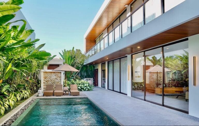 Modern villa with pool and tropical plants.
